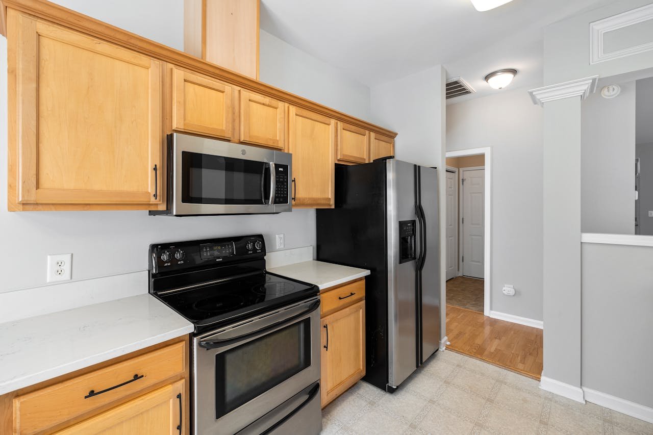 Contemporary kitchen featuring stainless appliances and light wood cabinets.